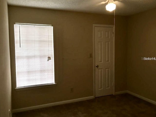 carpeted empty room with a textured ceiling and ceiling fan