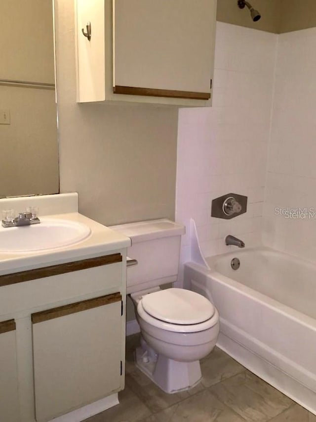 full bathroom with vanity, tiled shower / bath, and toilet