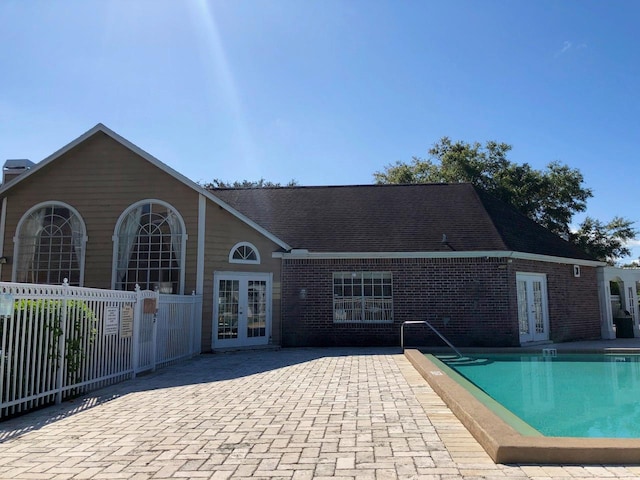 rear view of house with a patio area, french doors, and a community pool