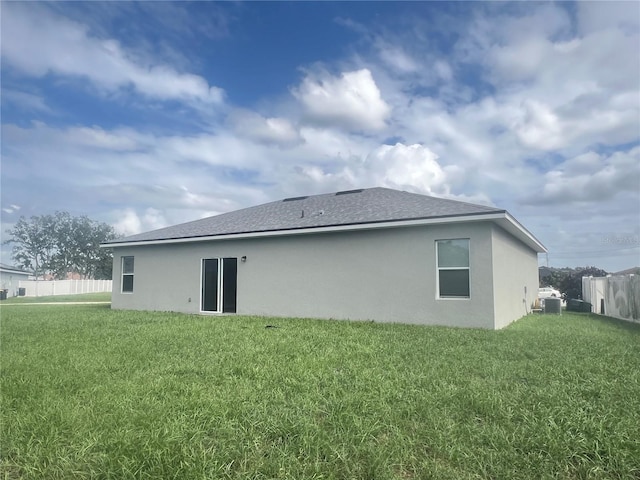 rear view of house featuring a yard