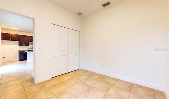 unfurnished bedroom with a closet and light tile patterned floors