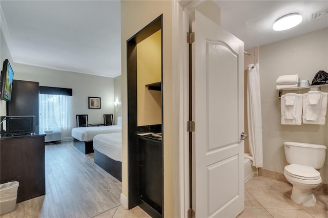 bedroom featuring ornamental molding and light wood-type flooring