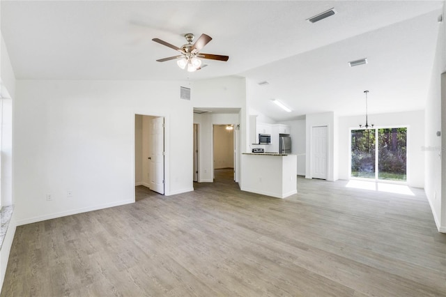 unfurnished living room with lofted ceiling, ceiling fan with notable chandelier, and light hardwood / wood-style floors