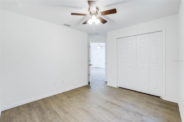 unfurnished bedroom featuring a closet, light wood-type flooring, and ceiling fan