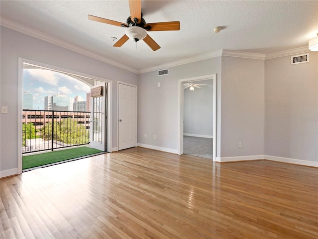 unfurnished room featuring ornamental molding, ceiling fan, a textured ceiling, and light hardwood / wood-style floors