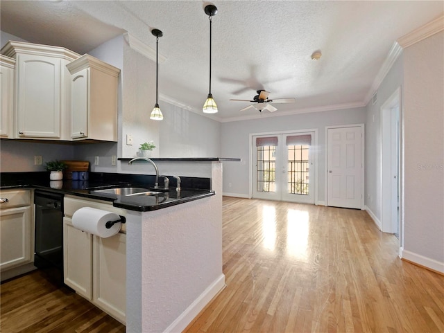 kitchen with crown molding, hanging light fixtures, sink, kitchen peninsula, and light hardwood / wood-style flooring