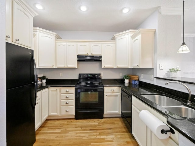 kitchen with black appliances, hanging light fixtures, sink, light hardwood / wood-style floors, and dark stone countertops