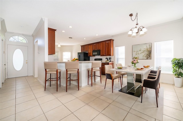 dining area with crown molding, light tile patterned floors, and an inviting chandelier