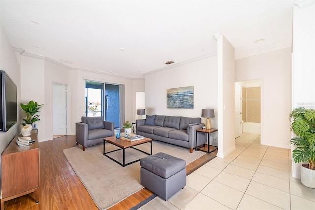 living room featuring crown molding and light hardwood / wood-style flooring