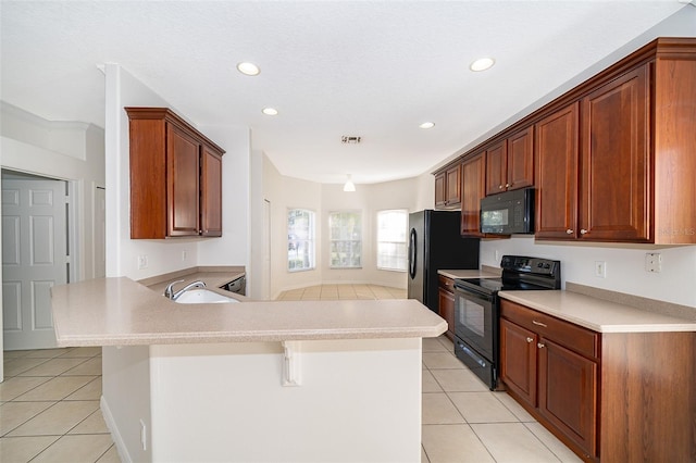 kitchen featuring kitchen peninsula, black appliances, light tile patterned floors, and a kitchen bar