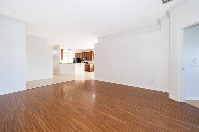 unfurnished living room with crown molding and light hardwood / wood-style floors