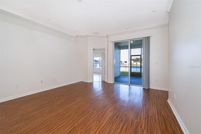 empty room with ornamental molding and dark hardwood / wood-style flooring