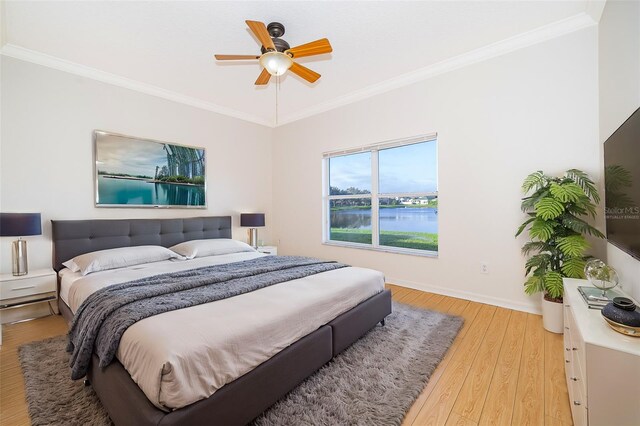 bedroom with ornamental molding, light hardwood / wood-style flooring, and ceiling fan