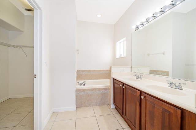 bathroom featuring vanity, tile patterned floors, and tiled tub