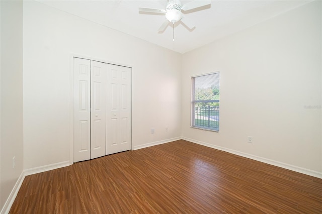 unfurnished bedroom featuring hardwood / wood-style floors, a closet, and ceiling fan