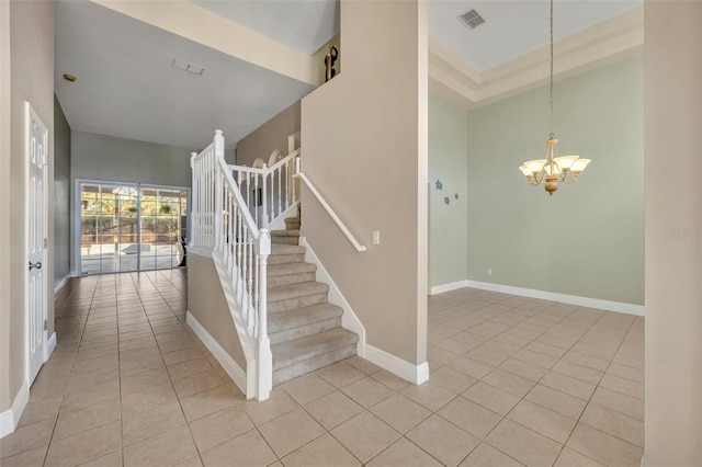 staircase featuring a chandelier, tile patterned floors, and a high ceiling