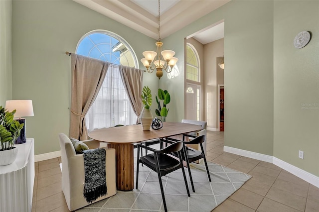 dining room featuring a notable chandelier, a towering ceiling, and light tile patterned floors