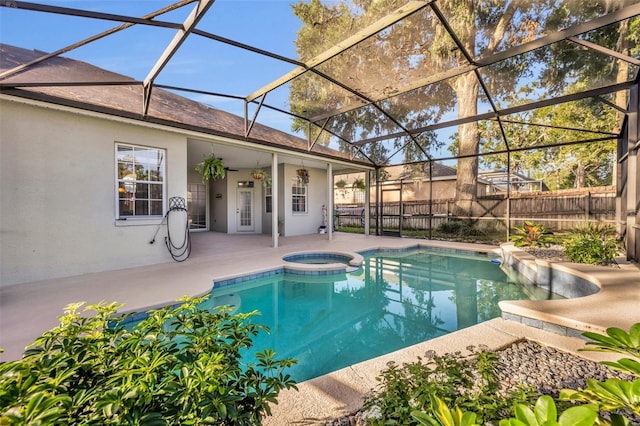 view of swimming pool featuring a patio, ceiling fan, an in ground hot tub, and glass enclosure