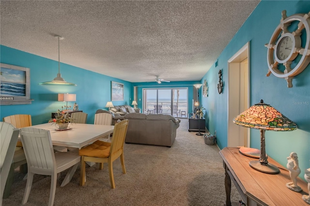 carpeted dining space featuring a textured ceiling and ceiling fan