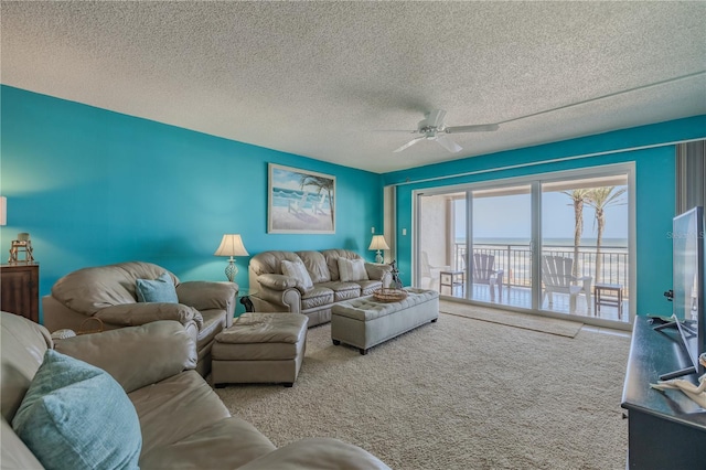 living room featuring ceiling fan, carpet flooring, and a textured ceiling