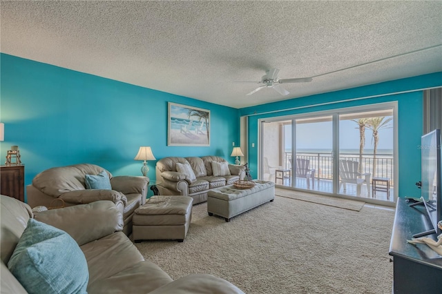 5501 S Atlantic Ave Unit 307, New Smyrna Beach, FL 32169 - living room with carpet, a ceiling fan, and a textured ceiling
