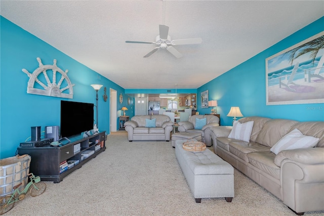 living room featuring a textured ceiling, light colored carpet, and ceiling fan