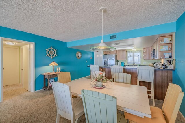 5501 S Atlantic Ave Unit 307, New Smyrna Beach, FL 32169 - dining room with light colored carpet, a textured ceiling, and visible vents
