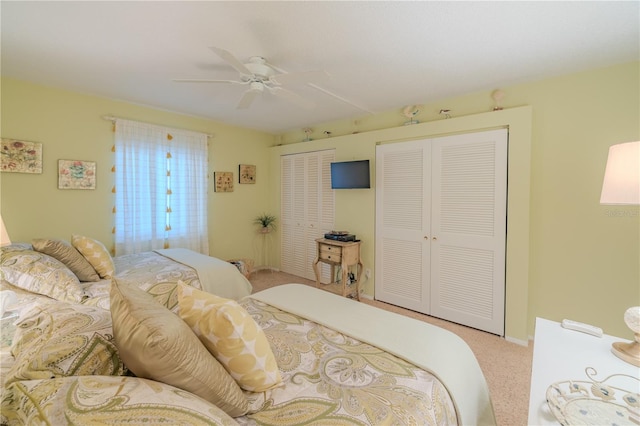 carpeted bedroom with two closets and ceiling fan