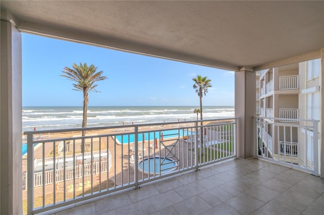 balcony with a water view and a beach view