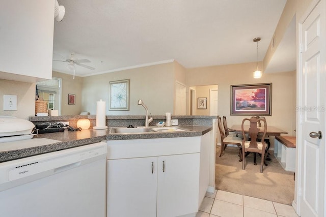 kitchen with light carpet, white dishwasher, sink, decorative light fixtures, and white cabinets