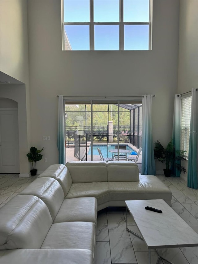 living room with a high ceiling and a wealth of natural light