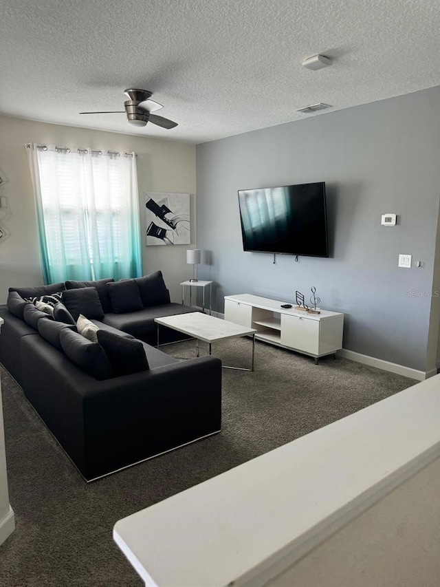 carpeted living room featuring ceiling fan and a textured ceiling