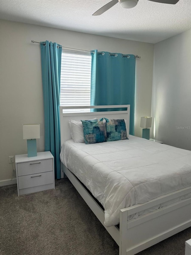 bedroom featuring ceiling fan, a textured ceiling, and dark carpet