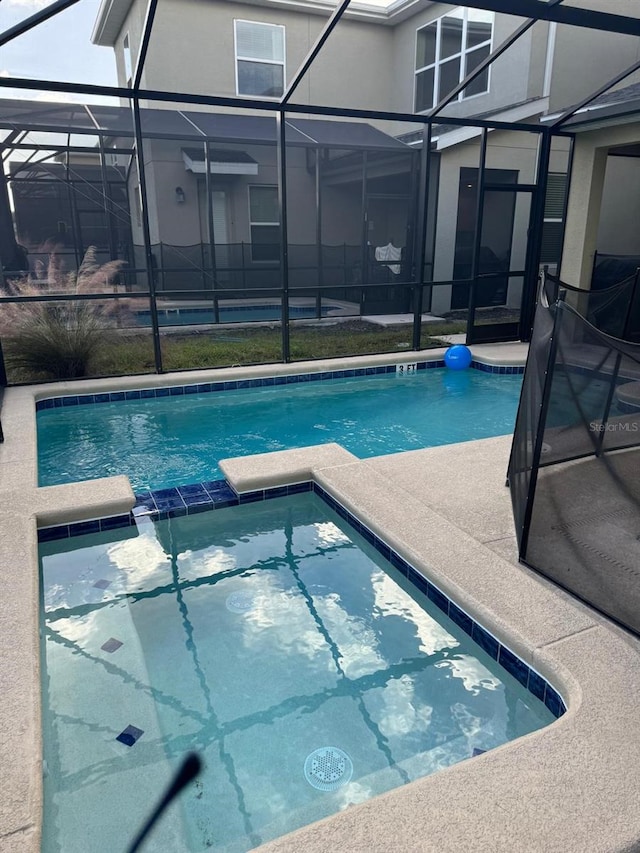 view of swimming pool with a patio and a lanai