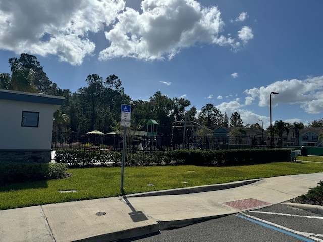 view of home's community with a playground and a yard