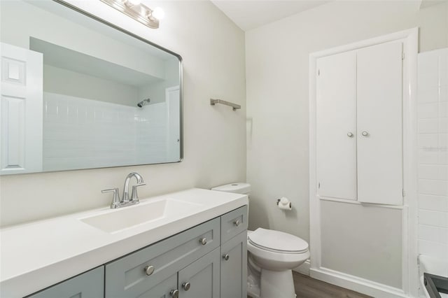 bathroom featuring vanity, toilet, hardwood / wood-style flooring, and a shower