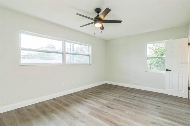 empty room featuring hardwood / wood-style floors, ceiling fan, and plenty of natural light