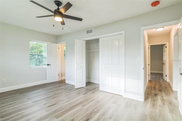 unfurnished bedroom with a closet, light hardwood / wood-style floors, and ceiling fan