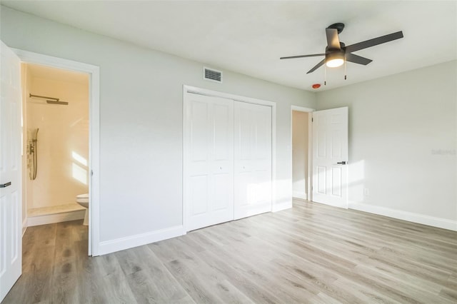 unfurnished bedroom with light hardwood / wood-style floors, a closet, ensuite bath, and ceiling fan