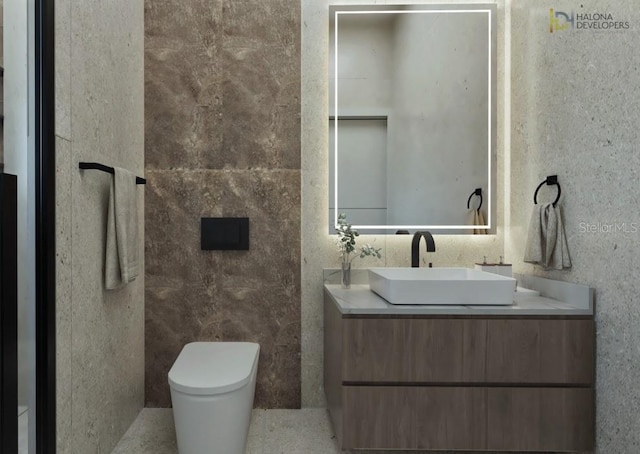 bathroom featuring vanity, toilet, and tile walls