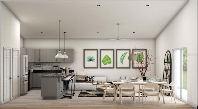 kitchen with stainless steel fridge, a kitchen bar, light hardwood / wood-style flooring, gray cabinets, and decorative light fixtures