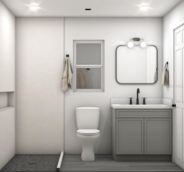 bathroom with vanity, toilet, and hardwood / wood-style flooring