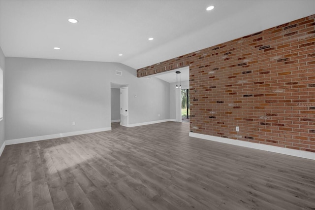 unfurnished living room with brick wall, vaulted ceiling, and wood-type flooring