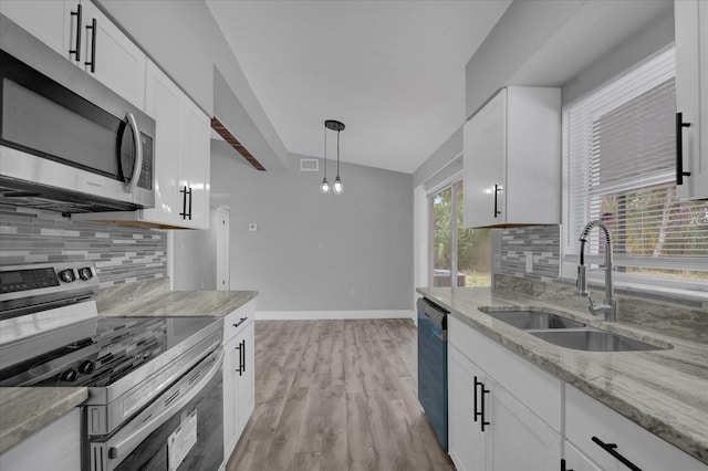 kitchen featuring stainless steel appliances, white cabinets, sink, and backsplash