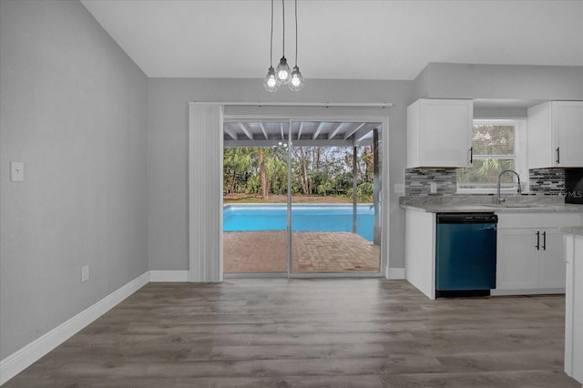 kitchen with backsplash, white cabinets, a wealth of natural light, and dishwashing machine