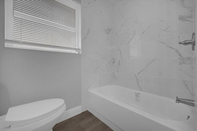 bathroom featuring shower / bathing tub combination, hardwood / wood-style flooring, and toilet