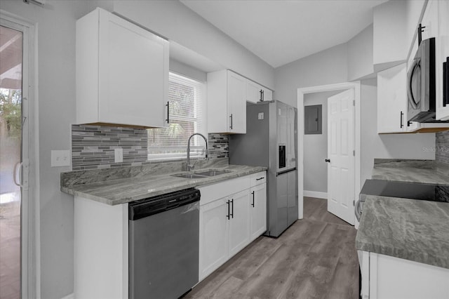 kitchen with stainless steel appliances, white cabinets, sink, and a healthy amount of sunlight