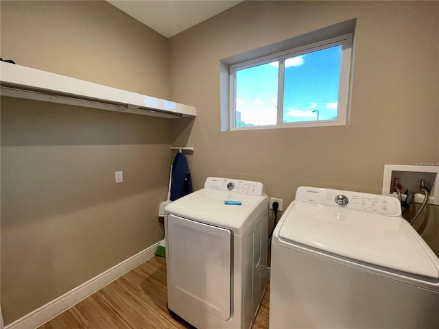 laundry room with light hardwood / wood-style flooring and washing machine and dryer