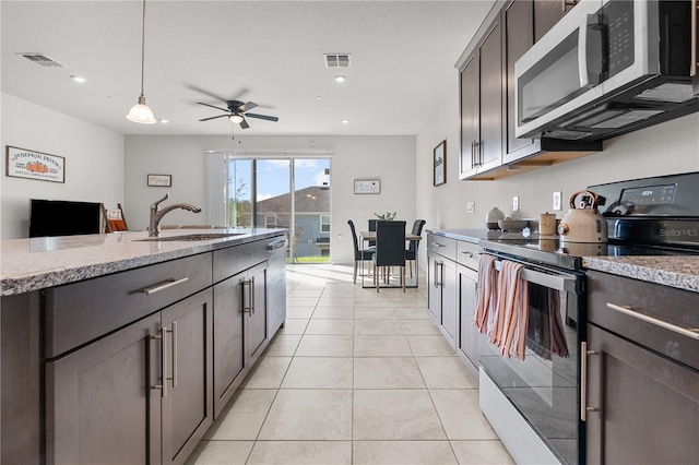 kitchen with sink, decorative light fixtures, dark brown cabinetry, and stainless steel appliances