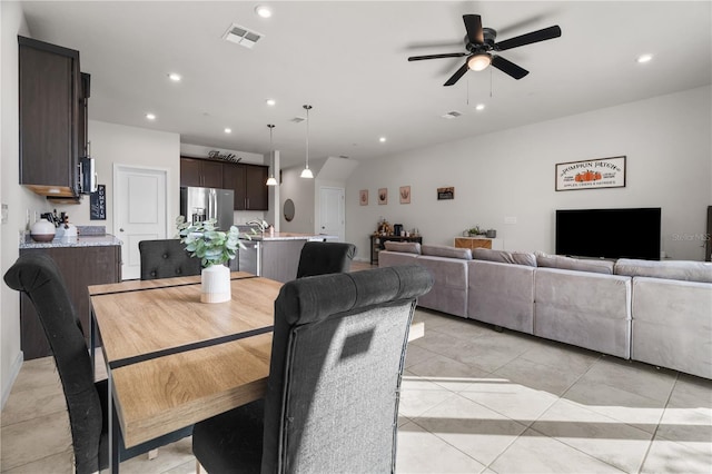 tiled dining area featuring ceiling fan and sink